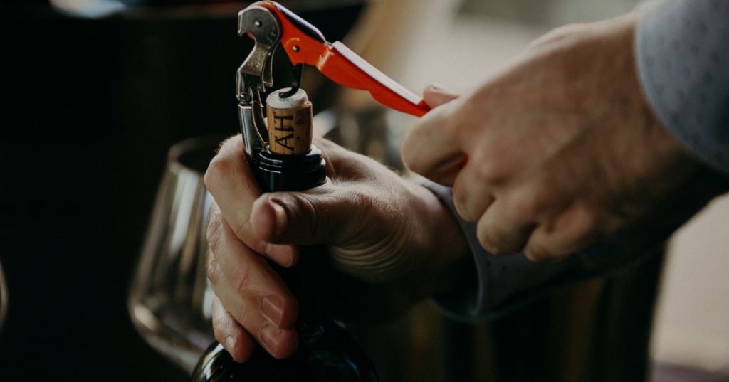 person opening cork wine